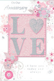 The anniversary card depicted here evokes the atmosphere of an intimate celebration in Richmond, perhaps after a leisurely walk through the riverside gardens. The design centres on the word 'LOVE,' where the letters are raised in soft, shimmering glitter, and the 'O' is replaced by a textured silver heart that glows against the blush background. This tactile focal point draws the eye immediately, giving the sense that fingertips would linger on its smooth yet slightly grainy surface, much like feeling the fine glitter and delicate foliage of a luxury card waiting beside a vase of roses. Surrounding the central word, an array of delicate pastel blooms unfolds in shades of blush pink, mauve, and muted ivory. The flowers are illustrated with a watercolor softness, their edges gently blurred, as though painted with a fine brush. Curving lines and swirling tendrils of vines weave through the blossoms, suggesting lightness and care, like the thoughtful placement of each stem in a romantic bouquet arranged by a local Richmond florist. Small decorative touches-tiny petals, graceful curls, and discreet butterfly motifs-add a sense of motion and whimsy, recalling an English spring garden awakening after a light rain. Fine hints of soft grey and silver run through the design, creating dimension without overpowering the gentle palette. The scripted words 'On Our Anniversary' and 'I love you today and always' are written in a refined, flowing hand that matches the calm, loving tone of the artwork. Overall, the card feels like a keepsake meant to accompany an anniversary flower delivery to homes near Richmond Park or along Twickenham Road, a tender reminder of a shared journey that continues to blossom.